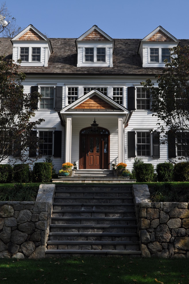 Immagine della facciata di una casa grande bianca classica con rivestimento in legno