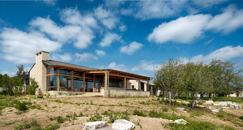 Mittelgroßes, Einstöckiges Landhaus Einfamilienhaus mit Steinfassade, weißer Fassadenfarbe, Pultdach und Blechdach in Austin