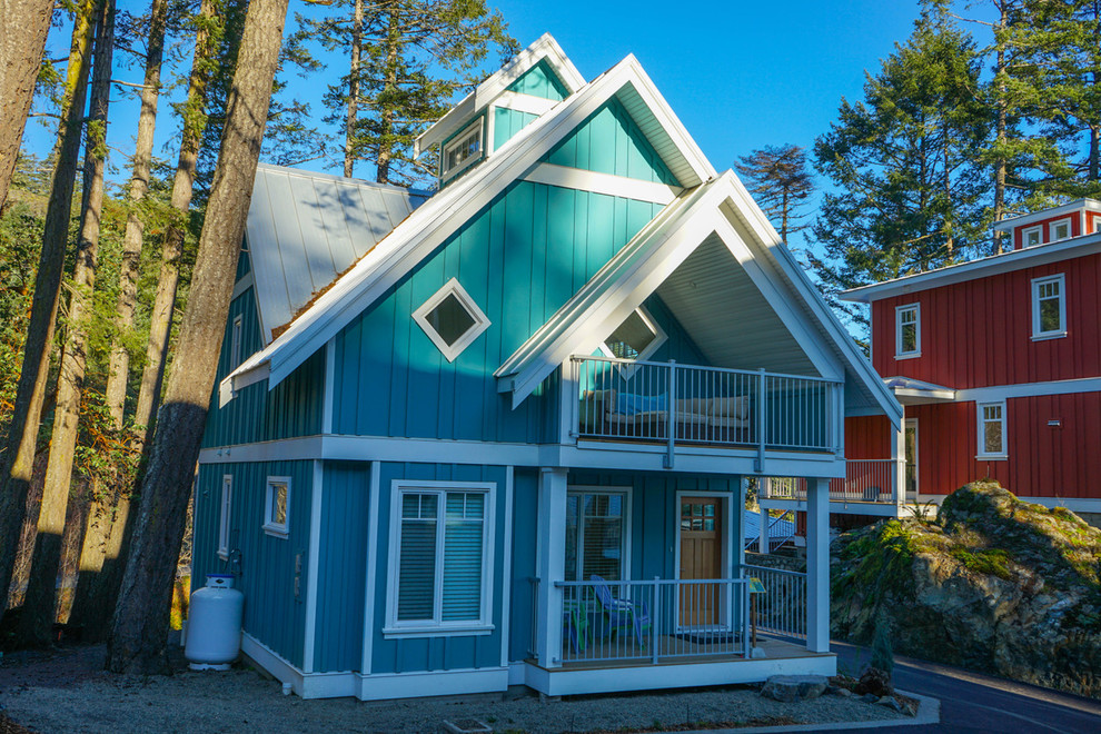 На фото: двухэтажный, синий частный загородный дом среднего размера в стиле неоклассика (современная классика) с облицовкой из ЦСП, двускатной крышей и металлической крышей
