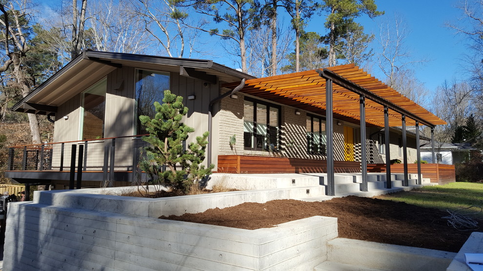 Ejemplo de fachada de casa beige vintage de dos plantas con revestimiento de ladrillo, tejado a dos aguas y tejado de metal
