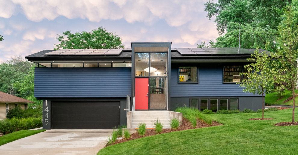 Cette image montre une façade de maison bleue vintage de taille moyenne et à niveaux décalés avec un toit à deux pans et un toit en shingle.
