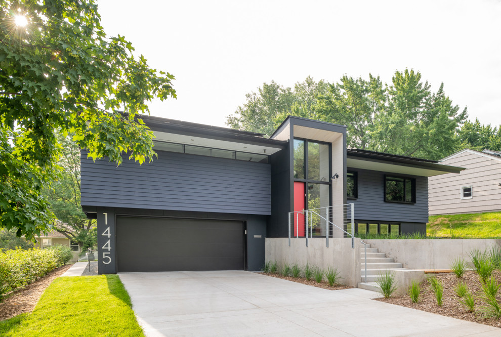 Diseño de fachada de casa azul vintage de tamaño medio a niveles con tejado a dos aguas y tejado de teja de madera