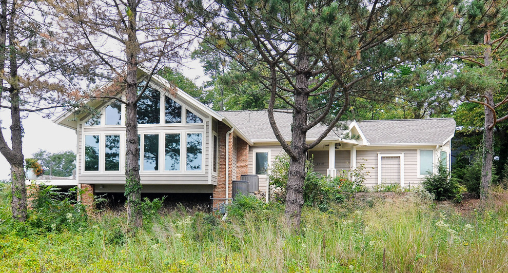 Imagen de fachada beige contemporánea con revestimiento de madera y tejado a dos aguas
