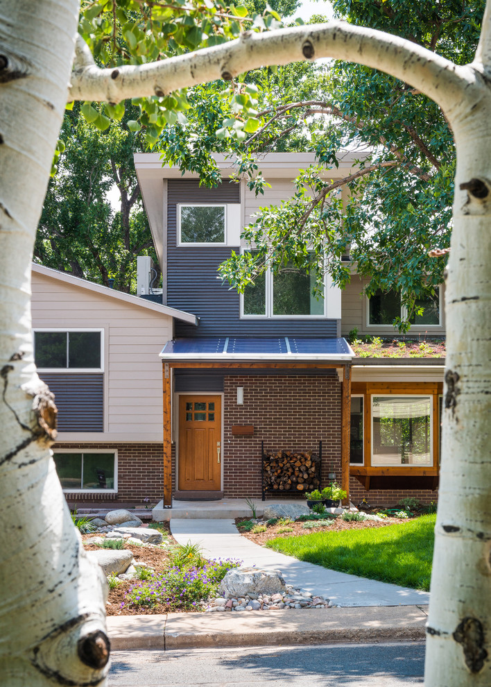 Inspiration pour une façade de maison bleue minimaliste de taille moyenne et à niveaux décalés avec un revêtement mixte, un toit en appentis et un toit en shingle.