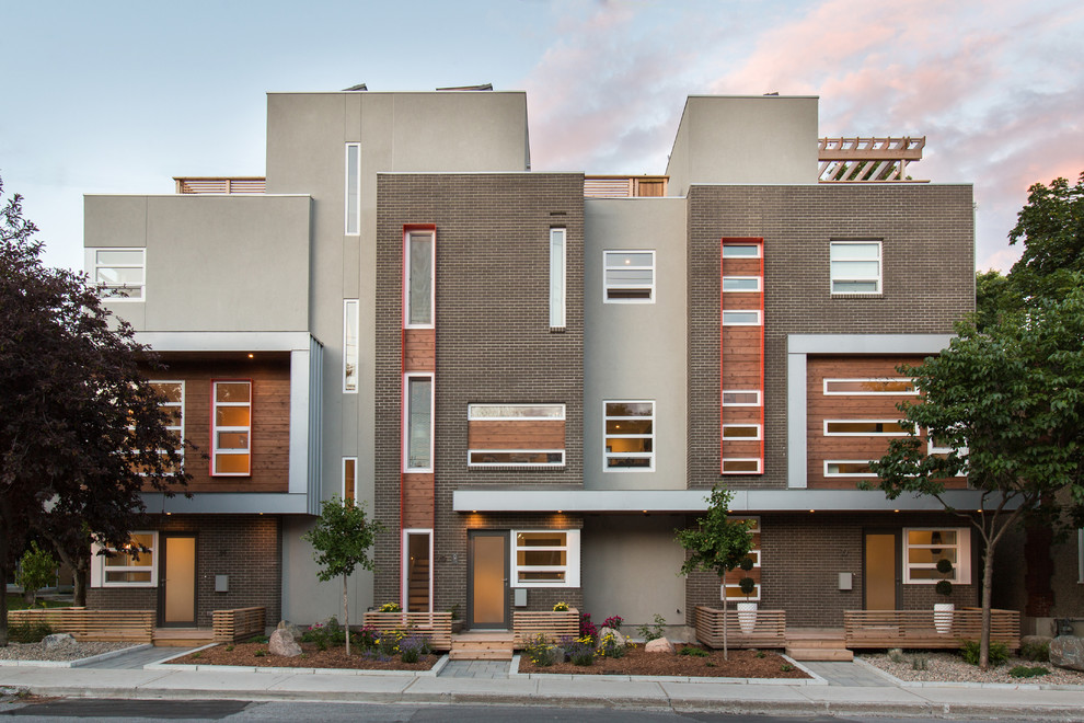 Foto på ett funkis brunt lägenhet, med tre eller fler plan, blandad fasad och platt tak