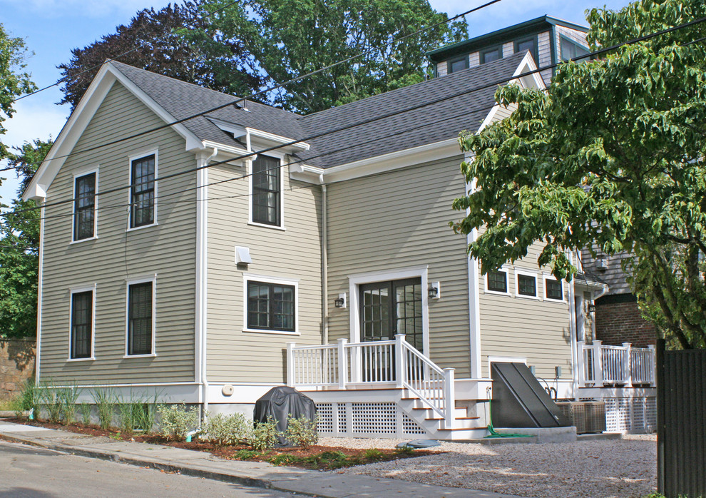 Aménagement d'une façade de maison beige classique en bois de taille moyenne et à un étage avec un toit à deux pans.