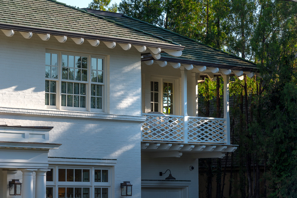 На фото: двухэтажный, кирпичный, белый частный загородный дом среднего размера в стиле фьюжн с вальмовой крышей и крышей из гибкой черепицы с
