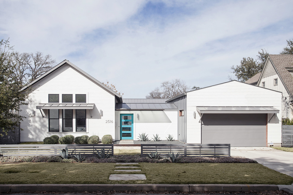 Einstöckiges, Mittelgroßes Country Einfamilienhaus mit weißer Fassadenfarbe, Satteldach, Vinylfassade und Blechdach in Austin