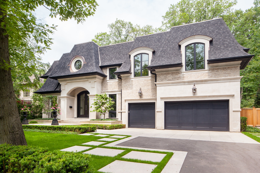 Example of a large transitional beige two-story stone house exterior design in Toronto with a hip roof and a shingle roof