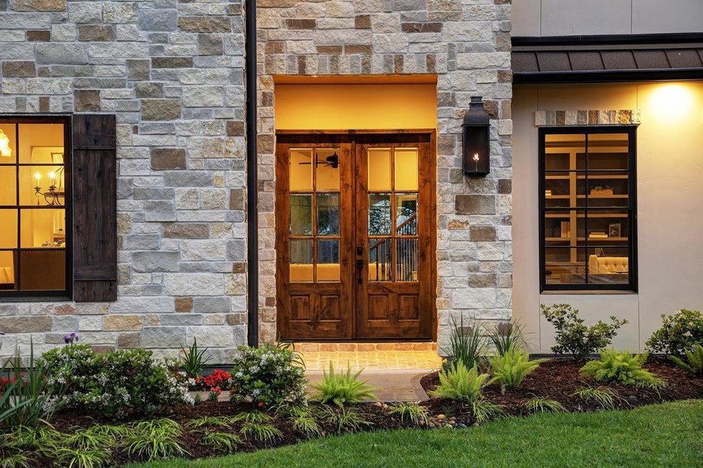 Ejemplo de fachada de casa beige tradicional renovada de dos plantas con revestimiento de piedra