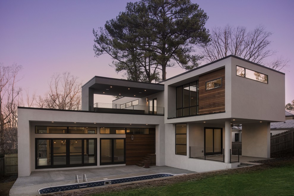 Inspiration for a large modern gray two-story stone flat roof remodel in Atlanta