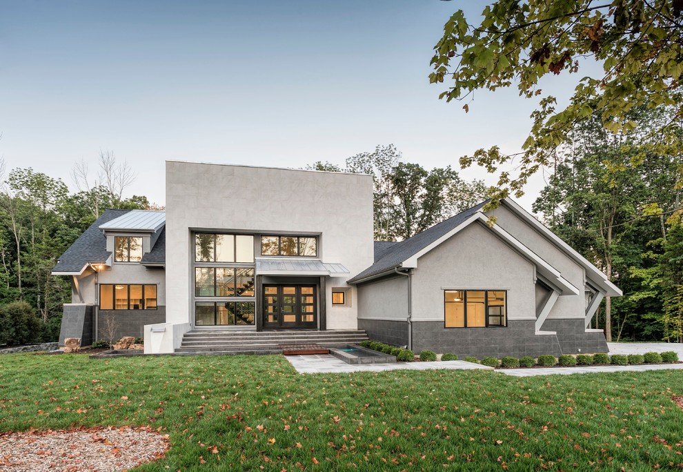 Inspiration pour une grande façade de maison grise minimaliste en pierre à un étage.