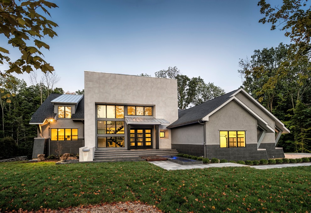 Cette photo montre une grande façade de maison grise moderne en pierre à un étage.