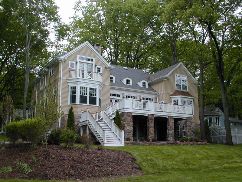 This is an example of a large and beige classic two floor house exterior in New York with wood cladding and a pitched roof.