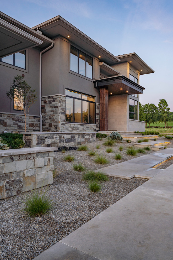 Large minimalist gray two-story stone house exterior photo in Columbus with a hip roof and a shingle roof