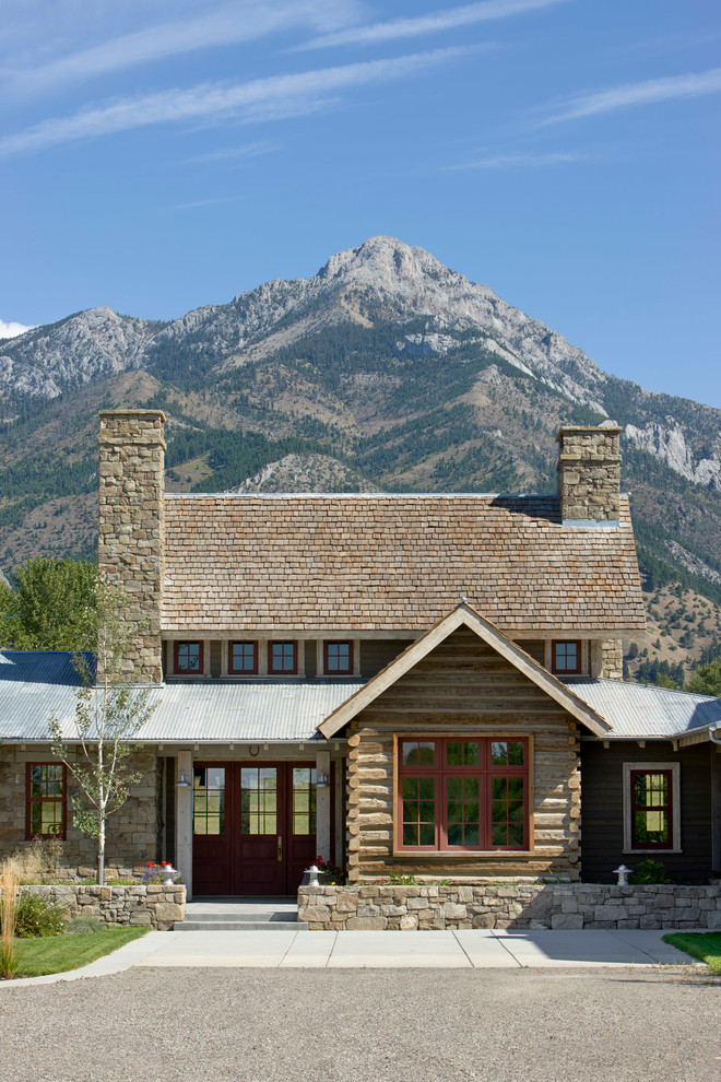 Immagine della facciata di una casa country a due piani con rivestimenti misti