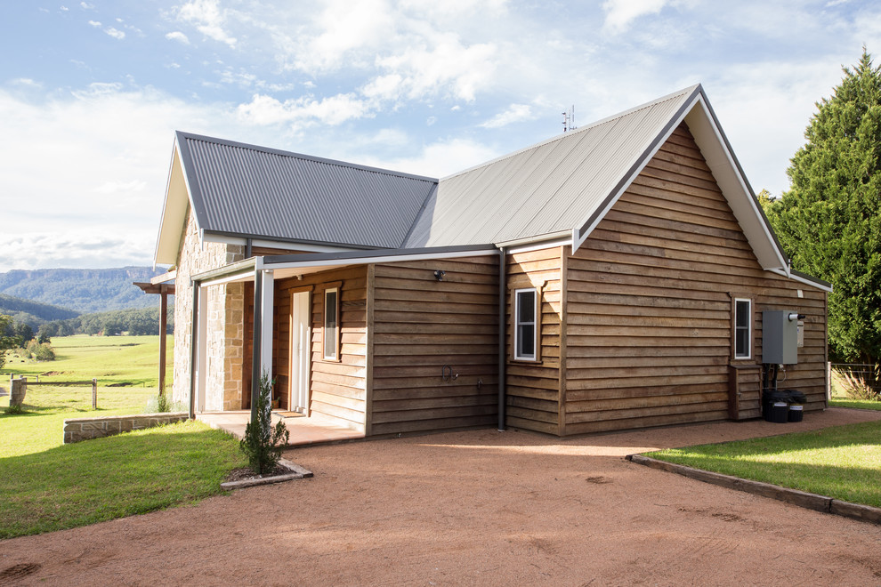 Diseño de fachada de casa de estilo de casa de campo pequeña de dos plantas con revestimiento de madera, tejado a dos aguas y tejado de metal