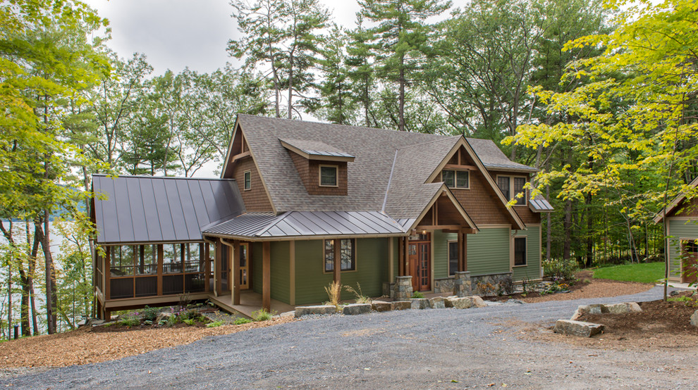 Стильный дизайн: большой, трехэтажный, деревянный, зеленый дом в стиле кантри с двускатной крышей - последний тренд