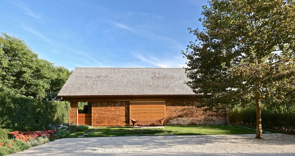 Foto della facciata di una casa country a un piano con rivestimento in legno e tetto a padiglione