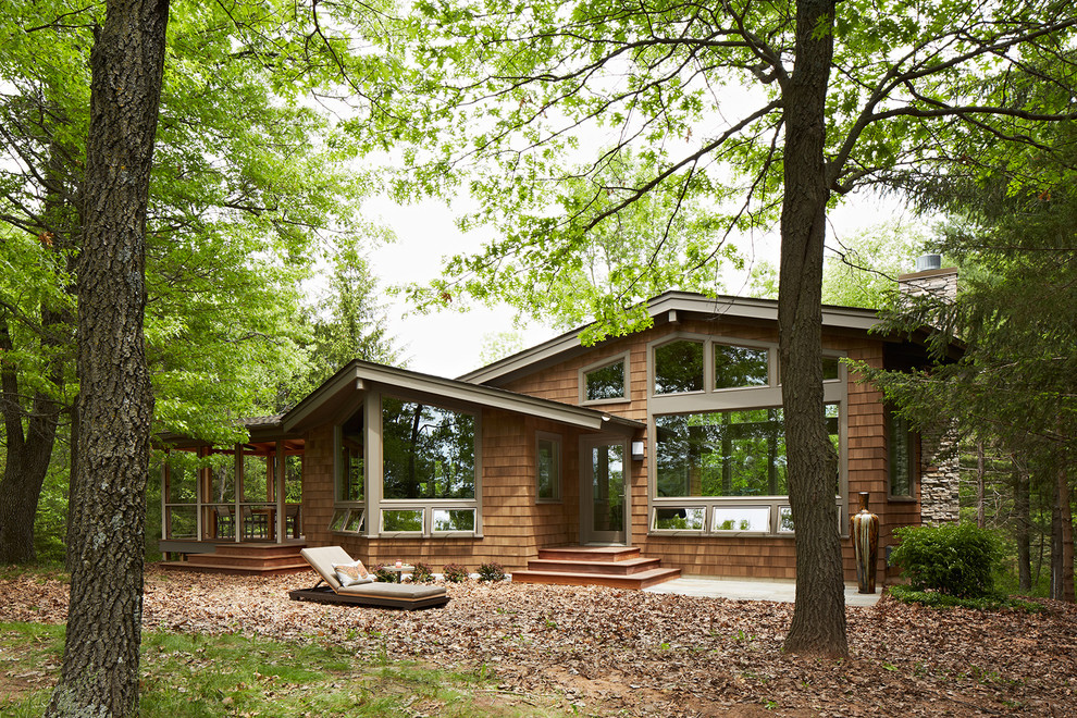 На фото: деревянный, коричневый, маленький, одноэтажный дом в современном стиле с двускатной крышей для на участке и в саду с