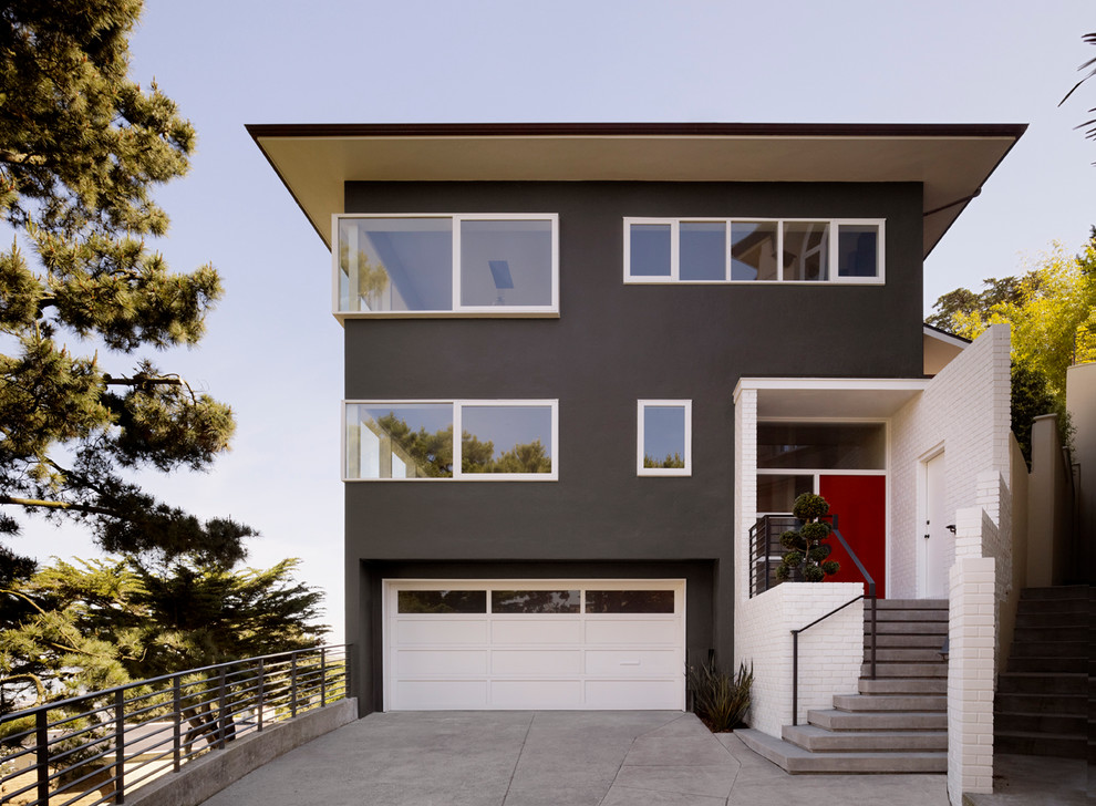 Immagine della facciata di una casa marrone moderna a tre piani con rivestimento in stucco