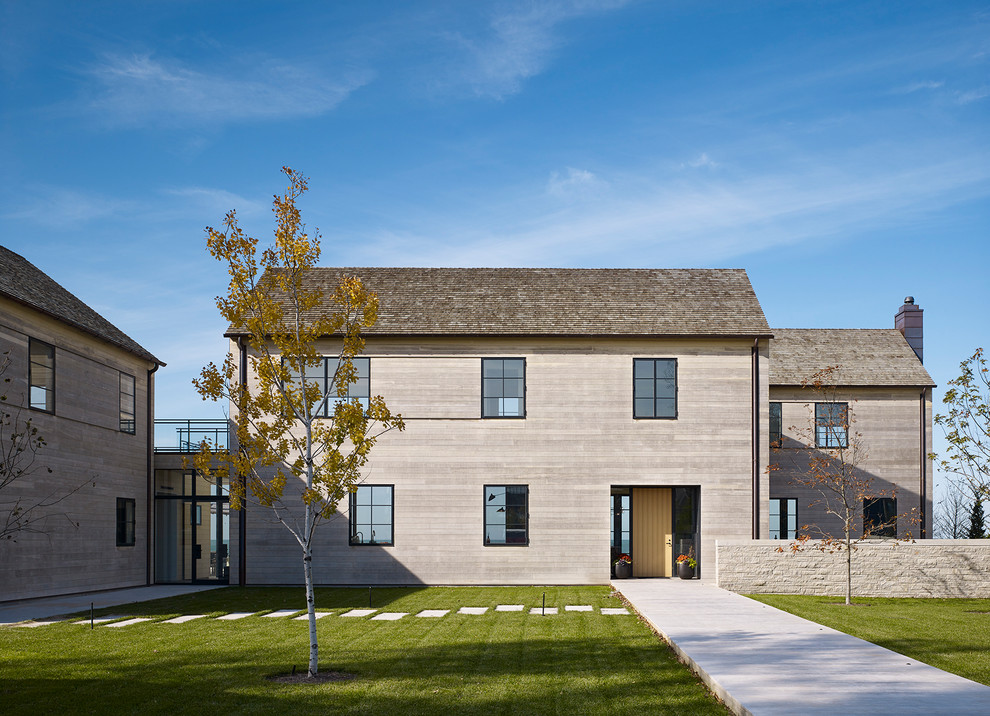 Cette photo montre une façade de maison grise tendance en bois à un étage avec un toit en appentis.