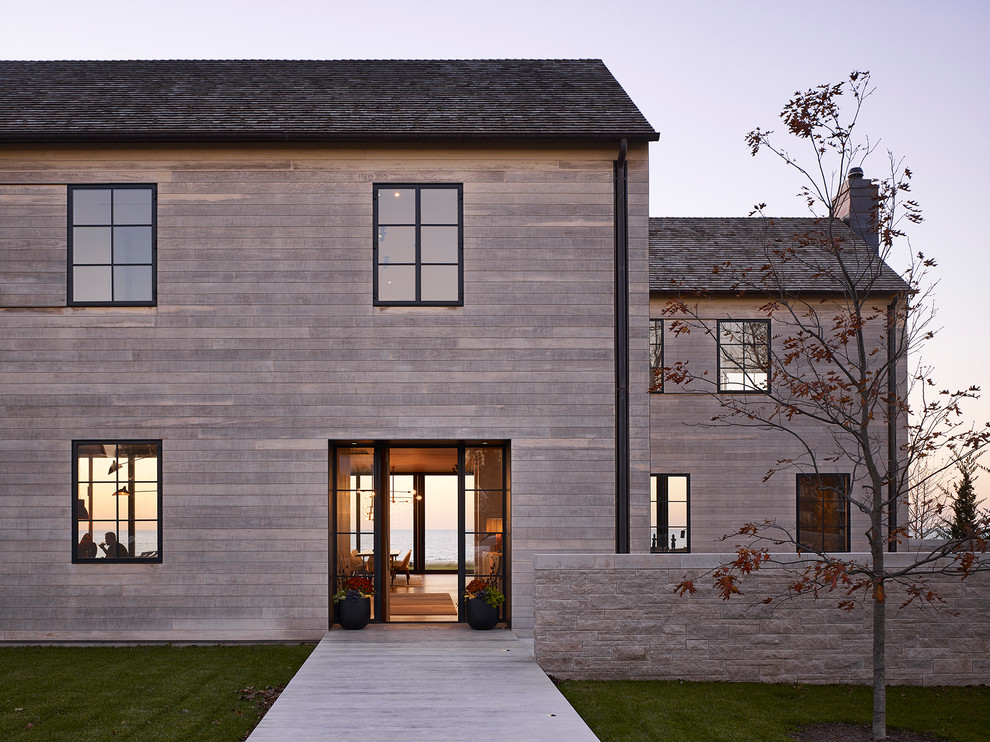 Inspiration pour une façade de maison grise minimaliste en bois à un étage avec un toit en appentis.