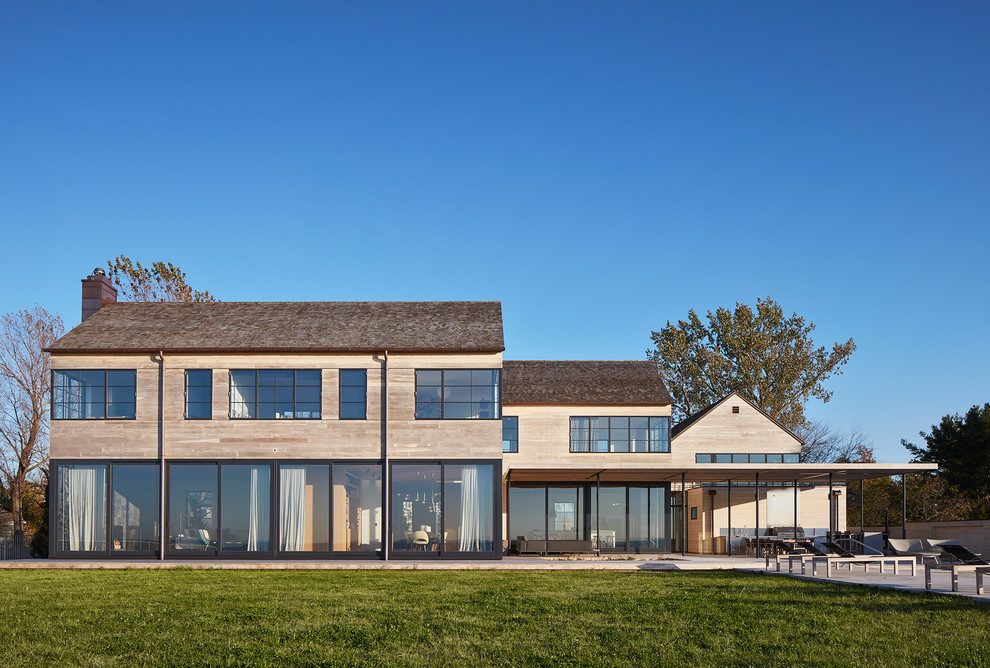 Cette image montre une façade de maison grise minimaliste en bois à un étage avec un toit en appentis.