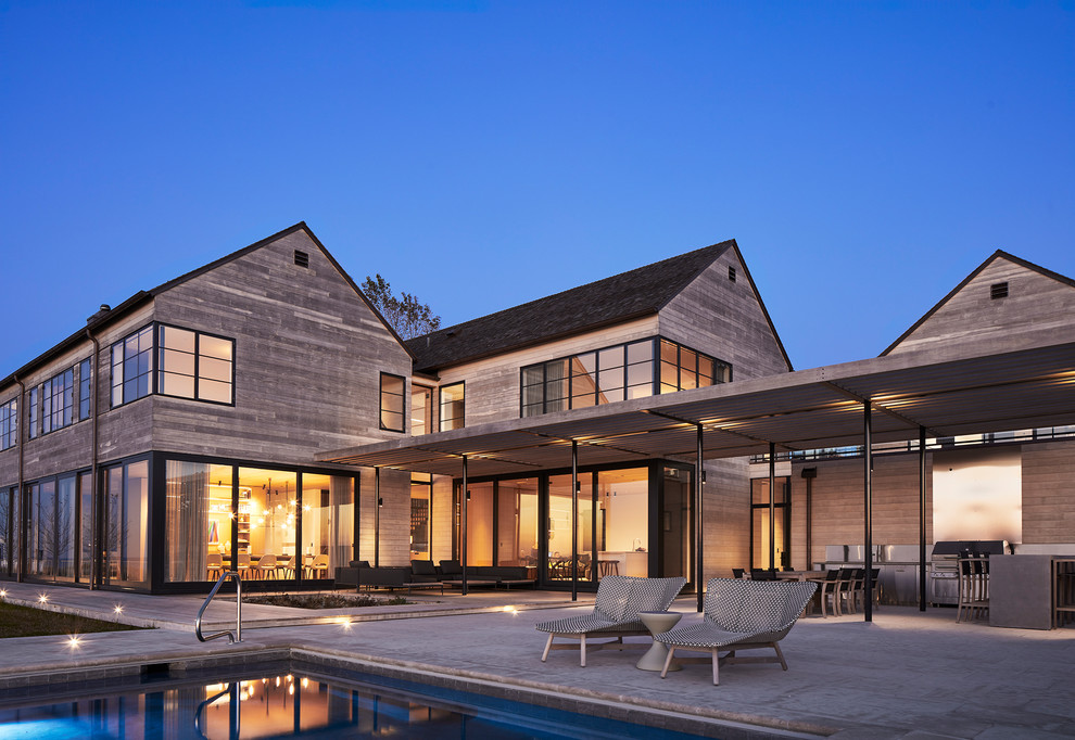 На фото: двухэтажный, деревянный, серый частный загородный дом в стиле модернизм с односкатной крышей