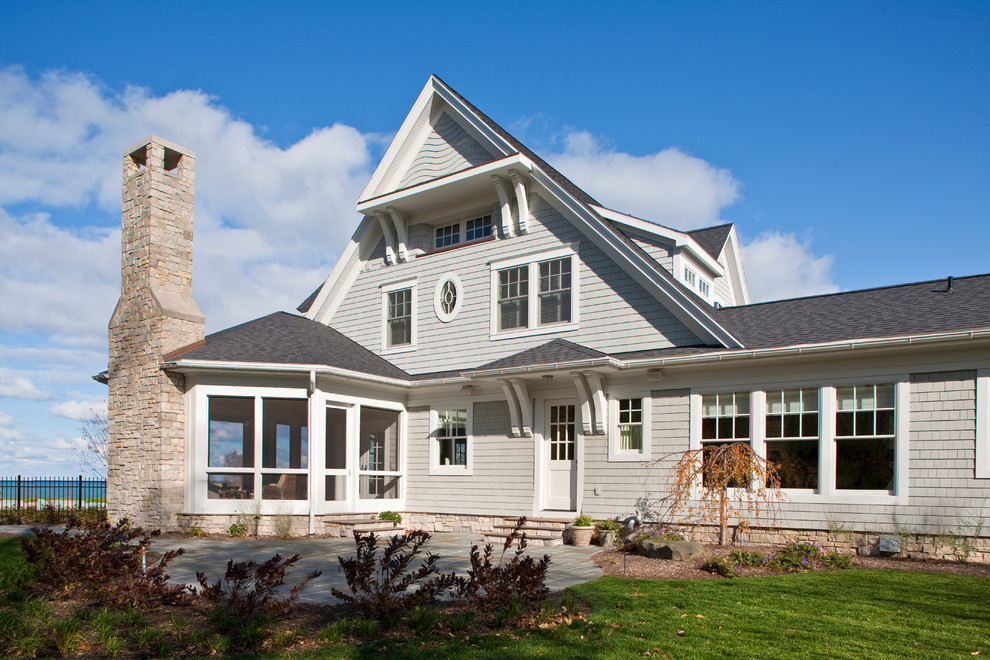 Idée de décoration pour une façade de maison grise marine en bois à un étage avec un toit à deux pans.