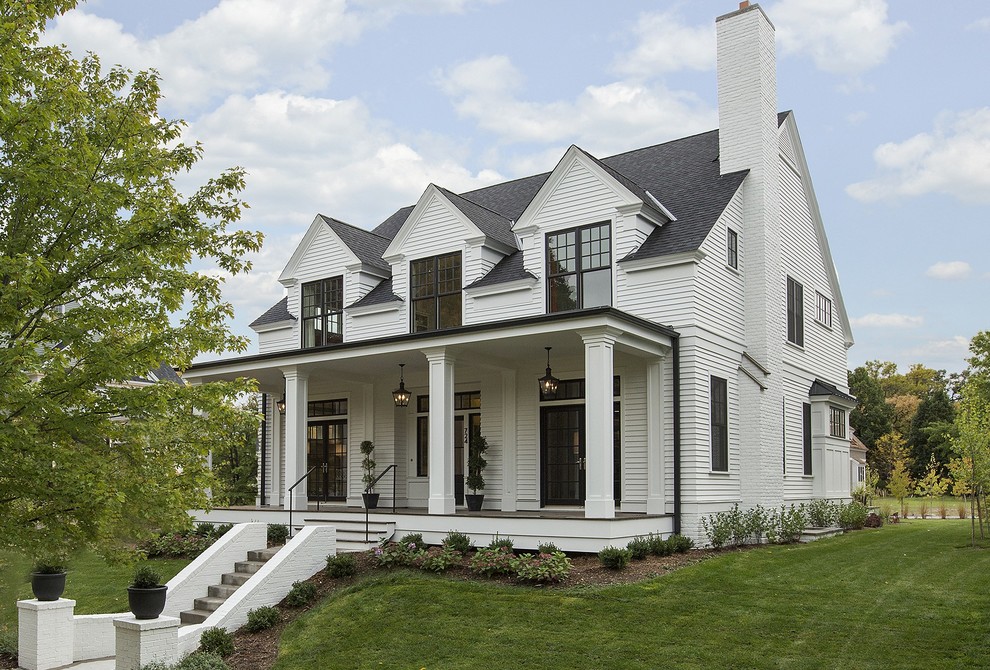 Immagine della facciata di una casa bianca classica a due piani di medie dimensioni con rivestimento in legno e tetto a capanna