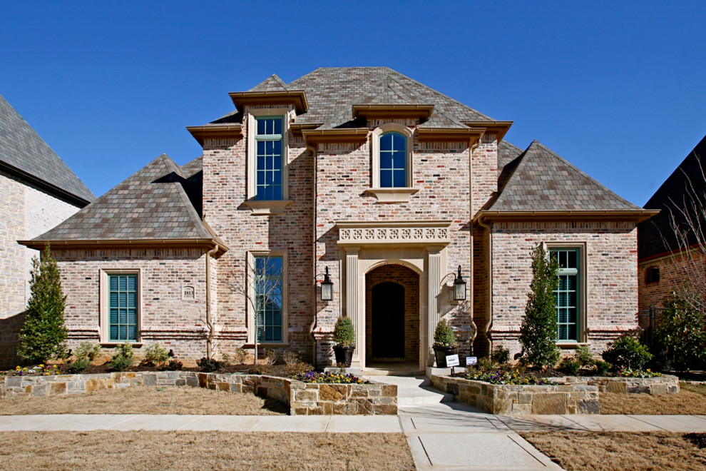 Medium sized and red traditional two floor house exterior in Dallas with stone cladding.