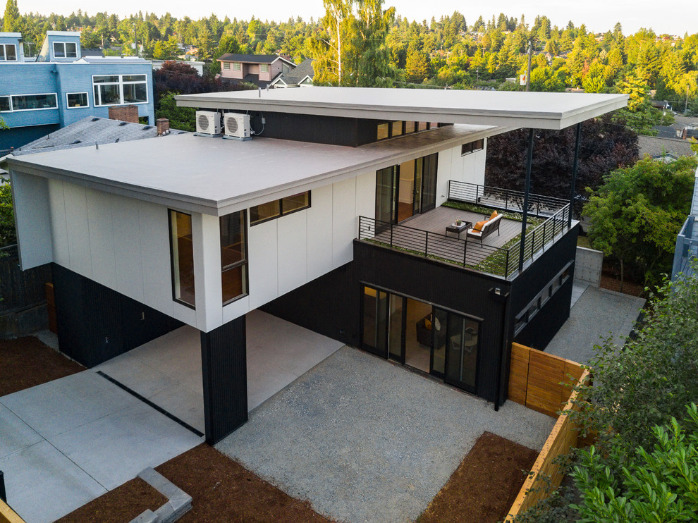 Пример оригинального дизайна: двухэтажный, разноцветный частный загородный дом среднего размера в стиле модернизм с облицовкой из металла, плоской крышей и зеленой крышей