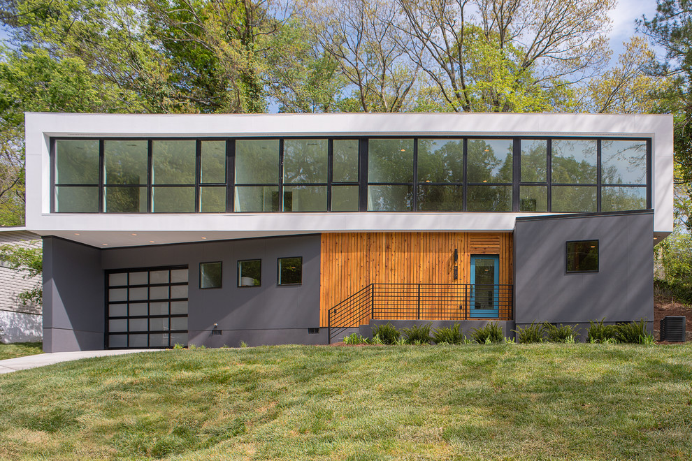 Mittelgroßes, Zweistöckiges Modernes Einfamilienhaus mit Mix-Fassade, grauer Fassadenfarbe und Flachdach in Sonstige