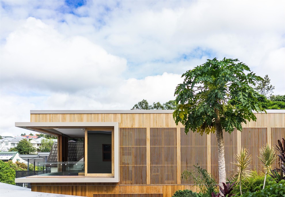 Foto della facciata di una casa marrone contemporanea a piani sfalsati di medie dimensioni con rivestimento in legno e copertura in metallo o lamiera
