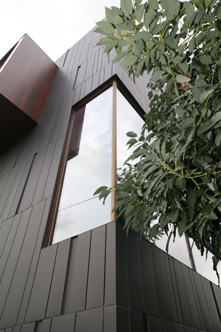 Idées déco pour une façade de maison métallique et noire contemporaine de taille moyenne et de plain-pied avec un toit plat.