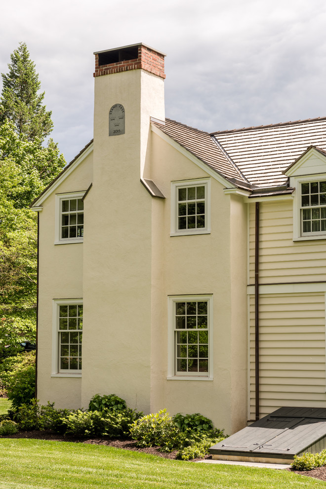 Idées déco pour une façade de maison beige classique en panneau de béton fibré de taille moyenne et à un étage avec un toit à deux pans et un toit en shingle.