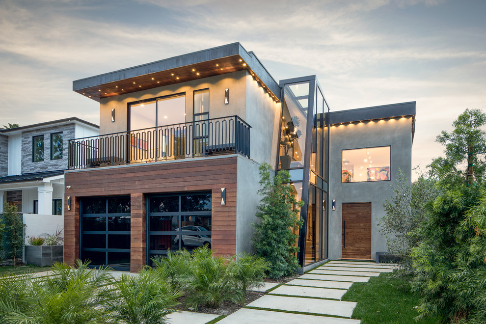 Cette image montre une grande façade de maison grise design en béton à un étage avec un toit plat.
