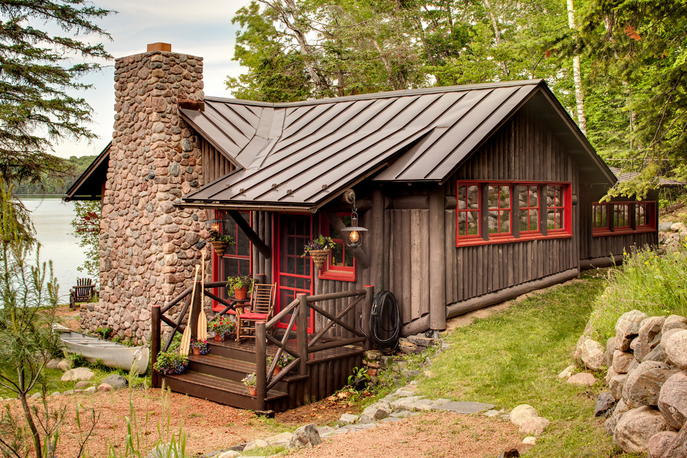 Aménagement d'une façade de maison marron montagne en bois avec un toit à deux pans et un toit en métal.