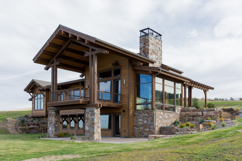 Cette photo montre une grande façade de maison marron montagne à un étage avec un revêtement mixte et un toit à deux pans.