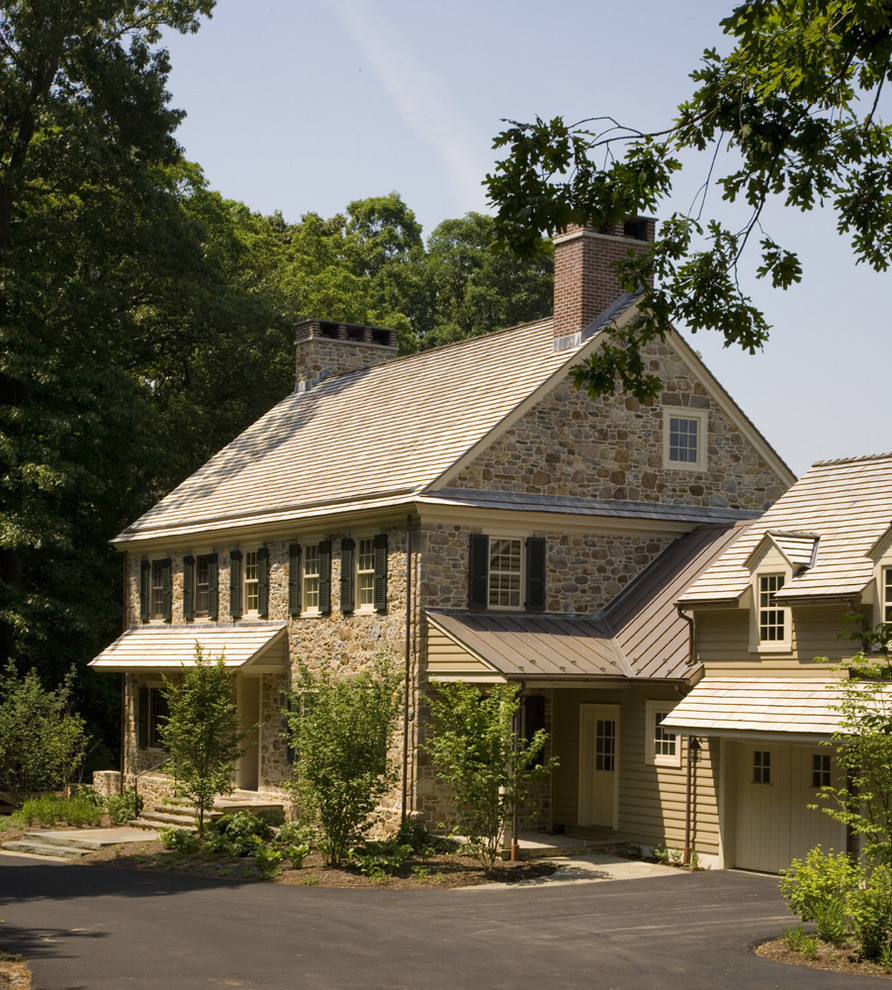 Esempio della facciata di una casa beige country di medie dimensioni con rivestimenti misti e tetto a capanna