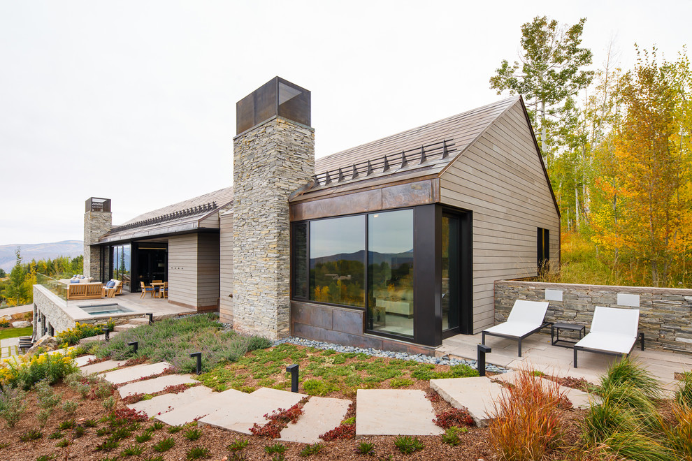 Foto de fachada de casa beige campestre con revestimiento de madera y tejado a dos aguas
