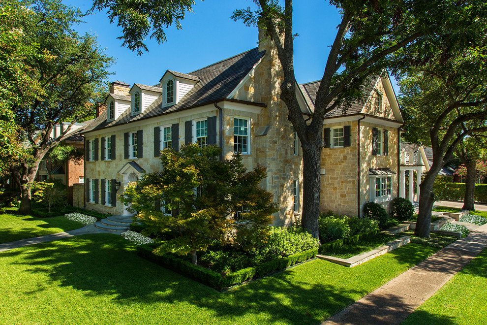 Mid-sized country beige three-story stone house exterior photo in Dallas with a tile roof