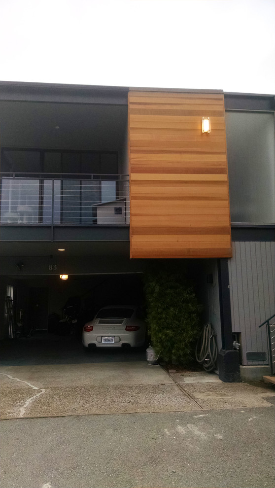 This is an example of a medium sized modern two floor house exterior in Other with wood cladding.