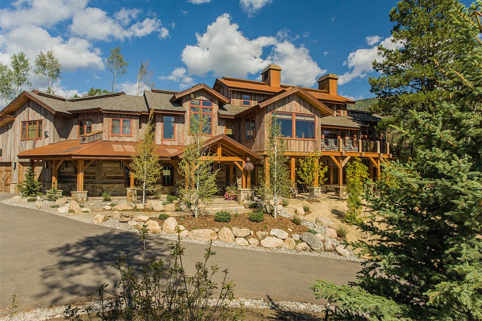 This is an example of a rustic two floor house exterior in Denver with wood cladding.