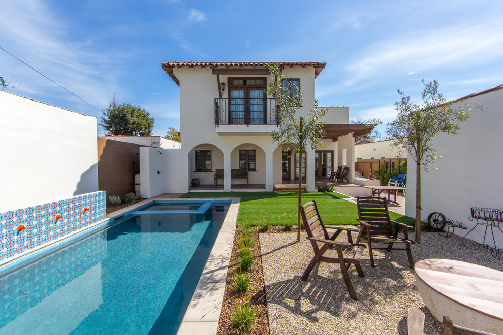 Modelo de fachada de casa blanca mediterránea de tamaño medio de dos plantas con revestimiento de estuco, tejado plano y tejado de teja de madera