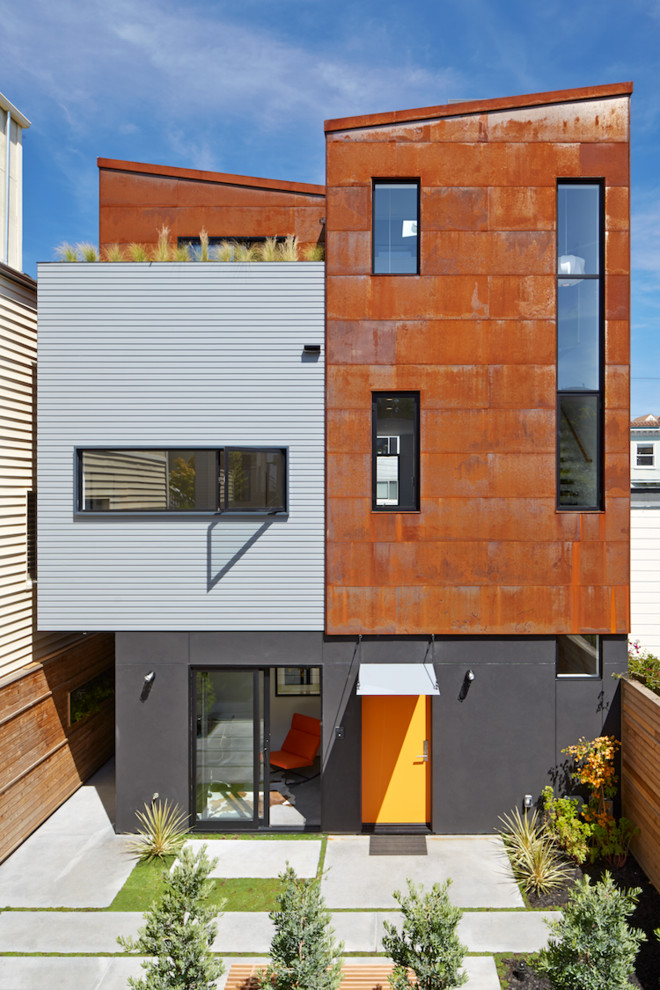Inspiration för små moderna oranga hus, med tre eller fler plan, metallfasad och pulpettak