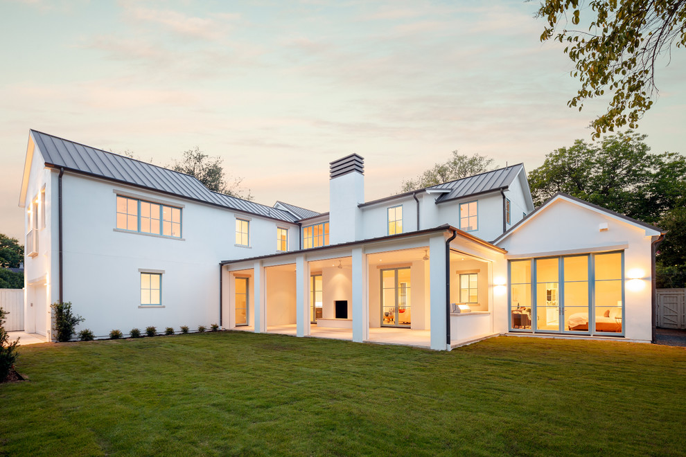 На фото: большой, двухэтажный, белый частный загородный дом в современном стиле с облицовкой из цементной штукатурки и металлической крышей