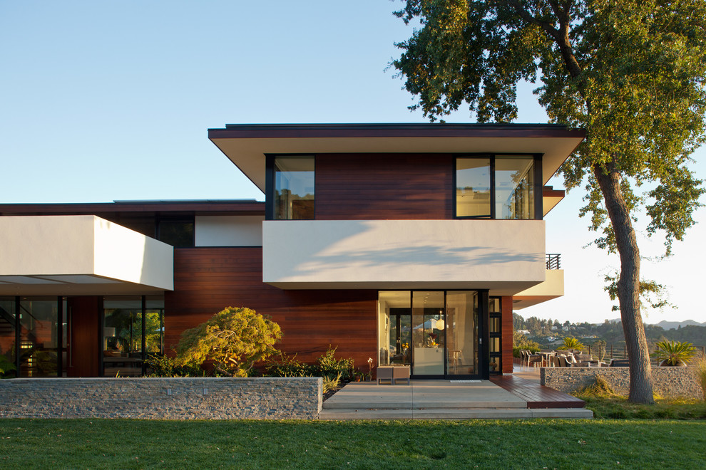 Inspiration pour une grande façade de maison minimaliste en bois à un étage avec un toit plat.