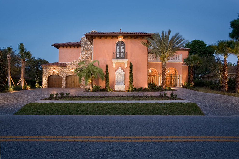 Großes, Zweistöckiges Mediterranes Haus mit Putzfassade und pinker Fassadenfarbe in Orlando